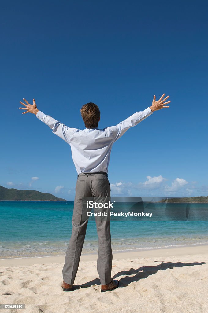 Бизнесмен, стоя на тропическом пляже в костюме с руками распространения - Стоковые фото Бизнес роялти-фри