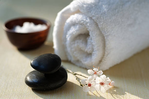zen spa com flores de cerejeira, massagem de pedras, sais e toalha - japanese culture massaging single flower nature - fotografias e filmes do acervo