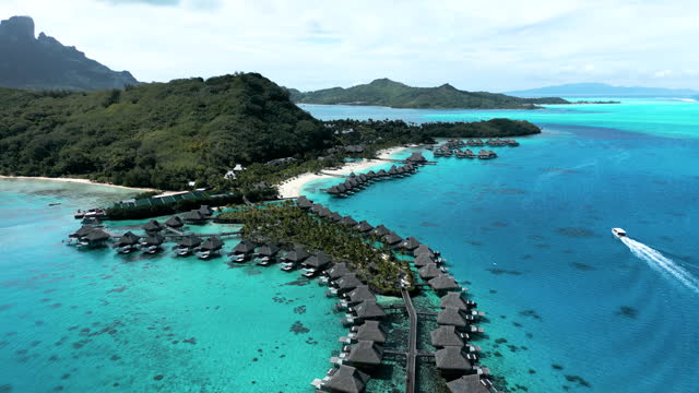 Aerial scenic view of tropical coastline and overwater bungalows