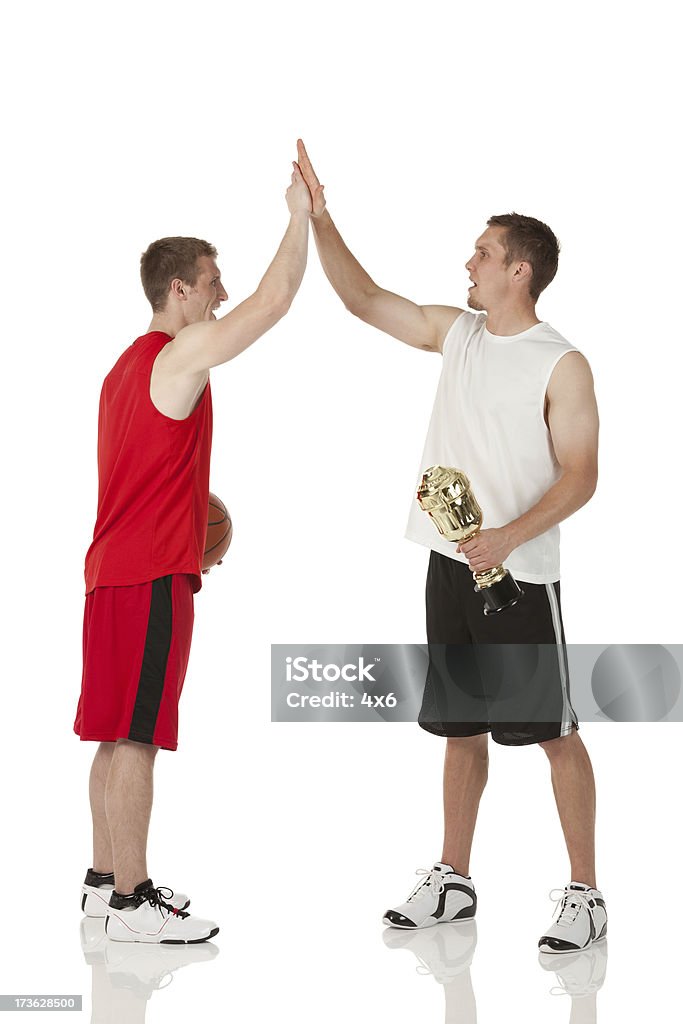 Giocatori di basket dando alta cinque a vicenda - Foto stock royalty-free di Dammi un cinque