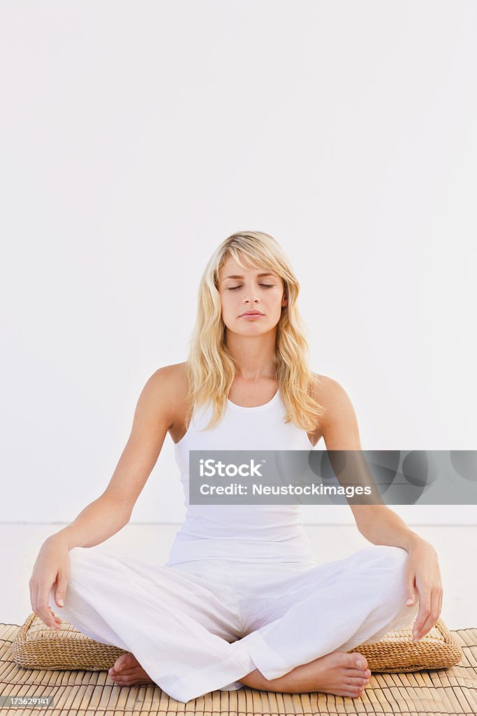 Giovane donna meditare su sfondo bianco - Foto stock royalty-free di Capelli biondi