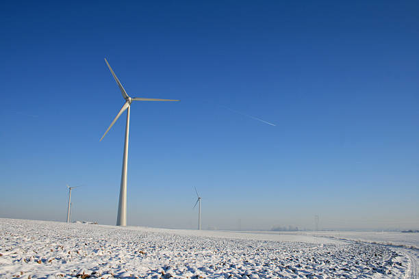 Wind turbine seen through bushes in winter
