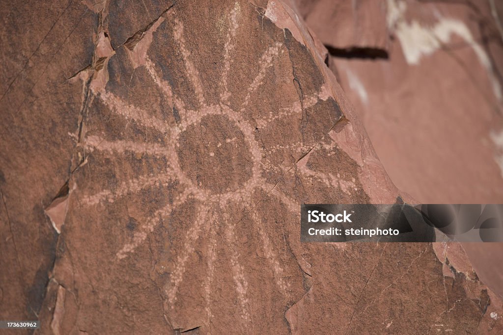 Petroglyph Sun Petroglyph Sun on a Red rock in the Saguaro National Park, Tucson, Arizona. Cave Painting Stock Photo
