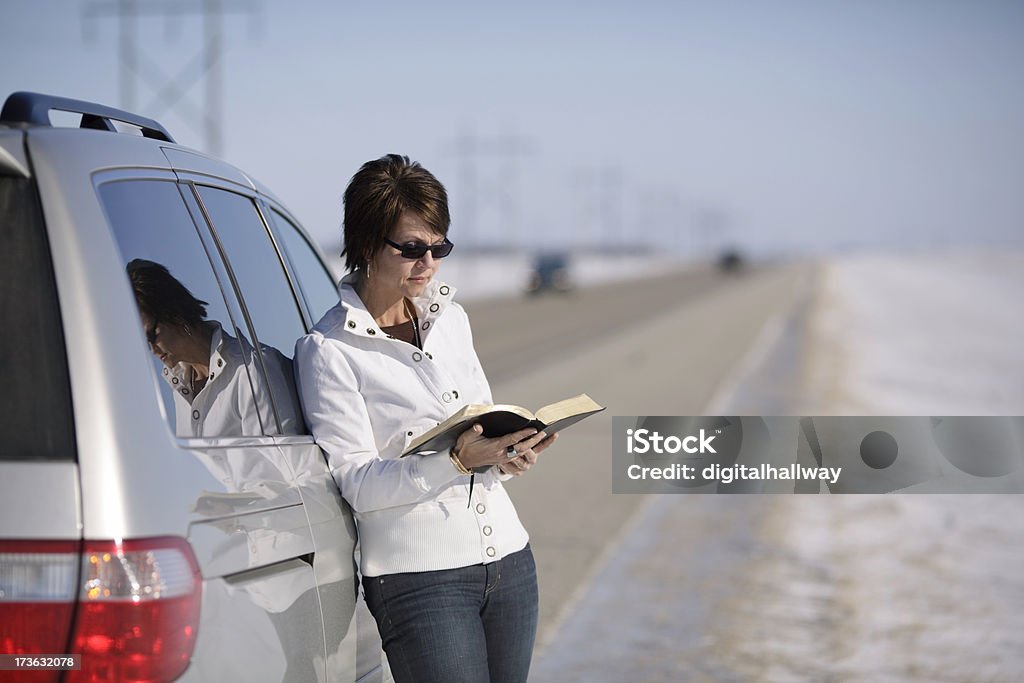 Donna lettura Bibbia su strada - Foto stock royalty-free di Bibbia