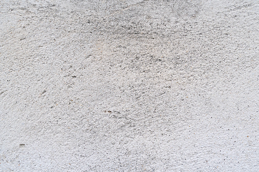 White-painted and textured roughcast wall with a rough texture, natural light and colors