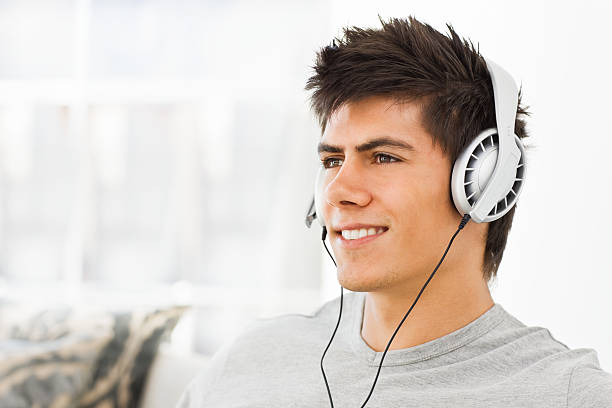 istock Smiling young man listening music 173632212