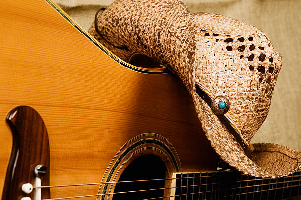 акустическая гитара и ковбойская шляпа - low key audio стоковые фото и изображения
