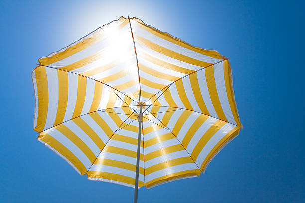 istock Yellow umbrella against the sun and blue sky 173633796