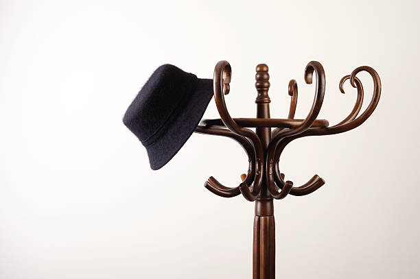 hat hanging on a coat rack hat hung on a vintage coat rack coat rack stock pictures, royalty-free photos & images