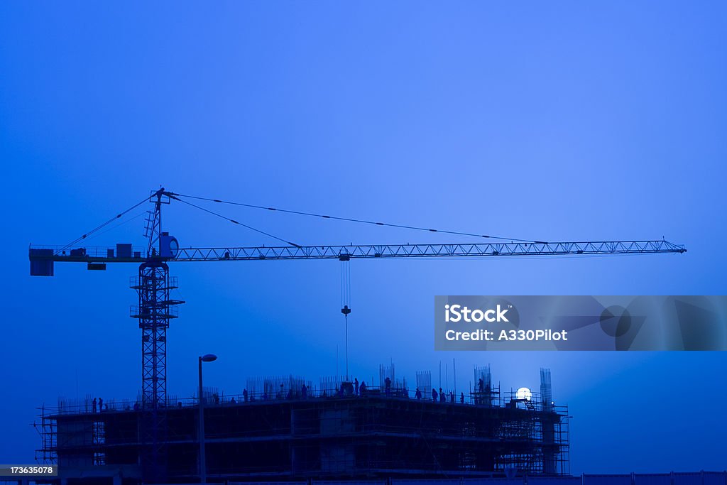 Night Construction Workers at night on a construction site. Blue Stock Photo