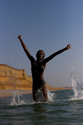 Bounding girl from the water. shooting at sunset