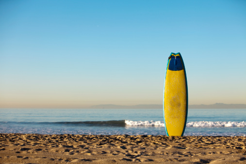A surfboard stands waiting to get wet. Huntington Beach, CA