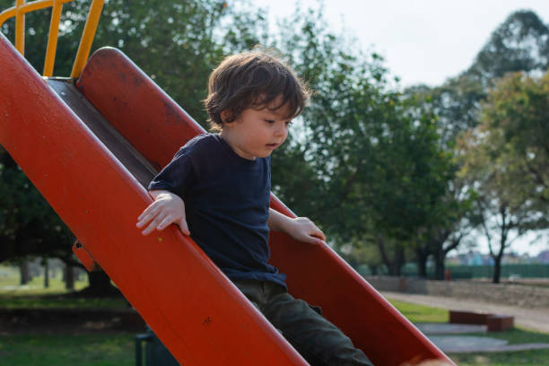 istock A little boy sliding down the slide in the playground 1736374217