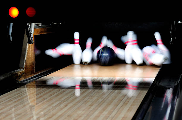 strike: bowling ball rollend down alley lanes schlagen pins - strike stock-fotos und bilder