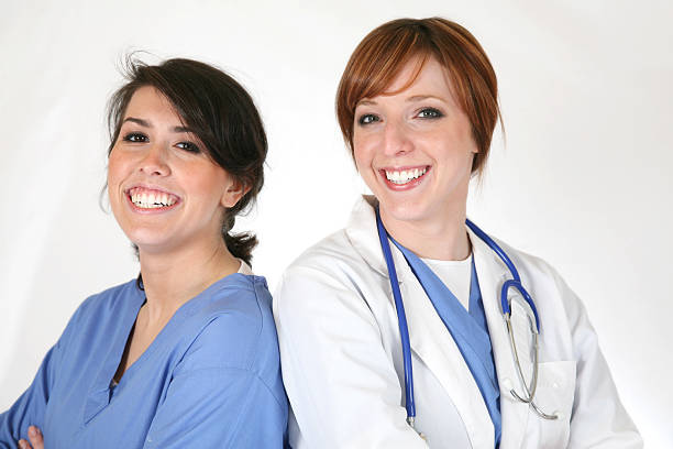 Smiling nurse with two nurse friends in hospital corridor