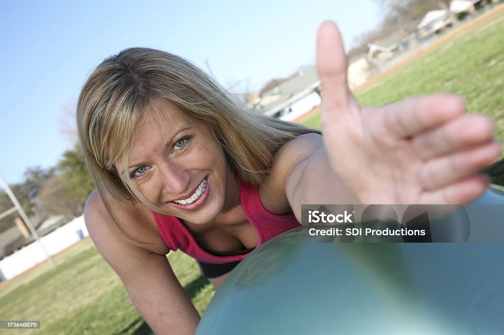Белокурая женщина, растяжение руки на Тренировочный мяч - Стоковые фото 20-29 лет роялти-фри