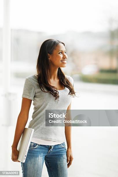 Young Woman Carrying Laptop And Looking Away Stock Photo - Download Image Now - African Ethnicity, Laptop, One Person