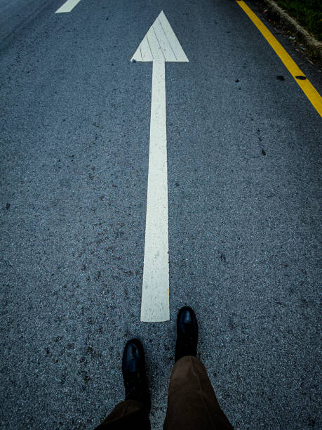 istock Two feet walking on the road leading forward. 1736406333