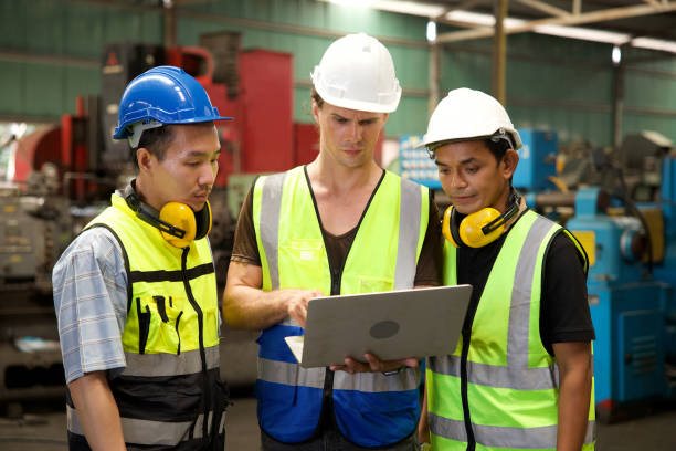 istock factory workers meeting and using laptop computer for work in machine factory 1736419691