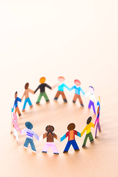 Small circle of ethnically diverse paper doll children playing. With copyspace.