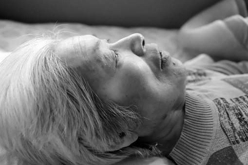 Close-up of the face of an elderly senior woman resting in a nursing bed