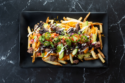 A top down view of a plate of carne asada fries.