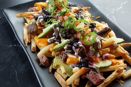 A view of a plate of carne asada fries.