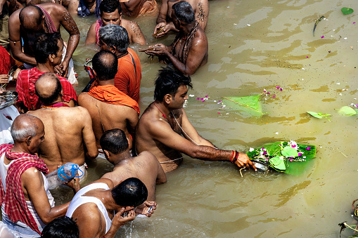 Kolkata, India - October 14, 2023 : Unknown People crowd at early morning in the shore of River Ganga to take part in the Hindu ritual called 'Tarpana' at Ahiritola ghat, North Kolkata in Mahalaya. 
Tarpaṇa  is a term in the Vedic practice that refers to an offering made to divine entities. It refers to the act of offering as well as the substance used in the offering. Tilatarpana is a specific form of tarpana involving libations offered to the pitri (deceased ancestors) using water and sesame seeds during Pitru Paksha or as a death rite.