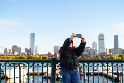 Woman using cell phone to take a selfie in Boston