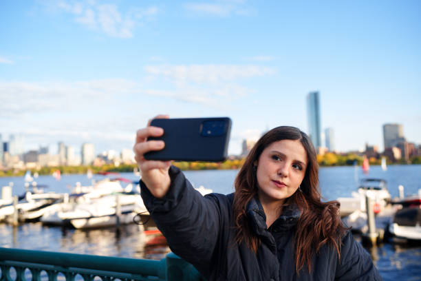 istock Woman using cell phone to take a selfie in Boston 1736486998