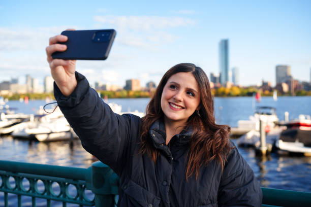 istock Woman using cell phone to take a selfie in Boston 1736487000