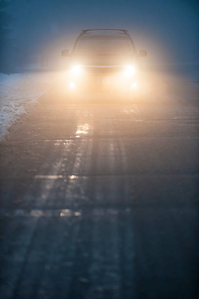 istock Oncoming car with headlights on driving through fog 173649608
