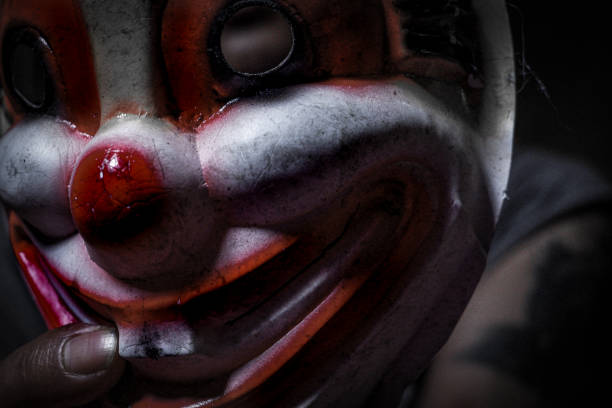 istock Holding halloween clown mask 1736496599
