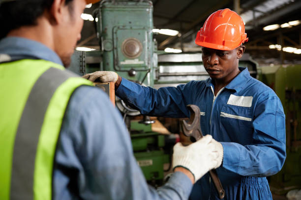 istock african technician giving or sending wrench to worker for fixing a machine 1736502500