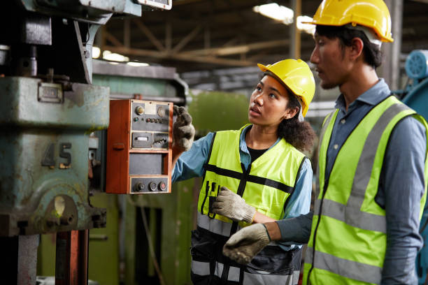 istock worker or engineer training and teaching how to use machine control with coworker in factory 1736502502
