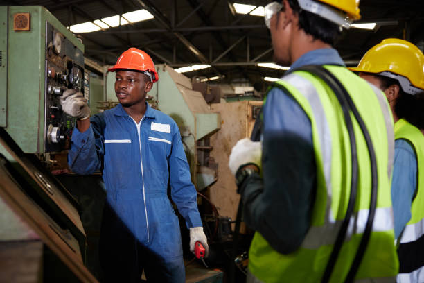 istock male african foreman training and teaching how to use machine control with workers in factory 1736502504