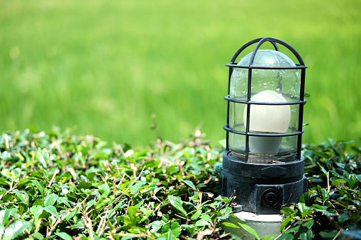 Solar Lantern and electrical lamp near the garden green field. Technology lighting concept