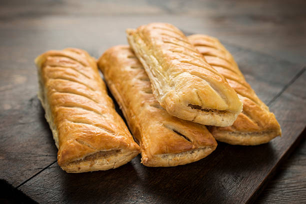 Sausage Rolls four Sausage Rolls on rustic wood. sausage roll stock pictures, royalty-free photos & images