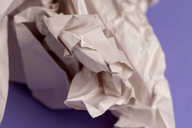 gray low-quality crumpled paper from recycled waste paper , crumpled recycled paper used for writing
