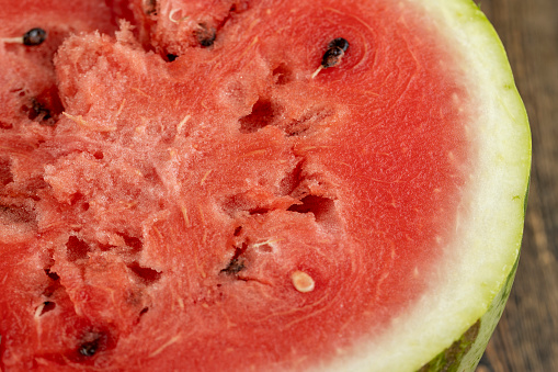 red and juicy pulp of ripe watermelon close-up, red fresh pulp of ripe watermelon with black seeds inside