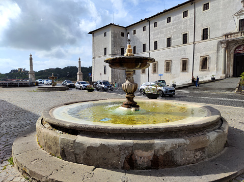 The historical fountain of Piazza di Corte in front of the Palazzo Chigi of Ariccia, located in the center of the town of Ariccia, near Rome, Italy.