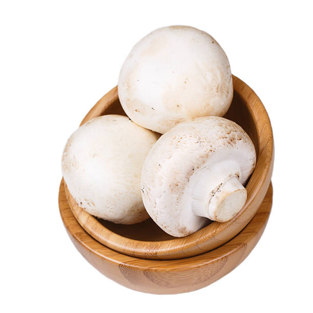 istock Mushrooms in a wooden bowl isolated on white background 173654829