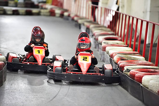 Little boy aged 6 driving a pedal go-kart, kart, soapbox car or cyclekart. Little boy is smiling and enjoying the spring ride.
