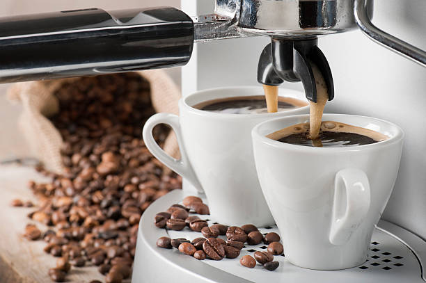 Coffee machine and coffee beans coffee machine makes two coffee with coffee beans on background espresso maker stock pictures, royalty-free photos & images