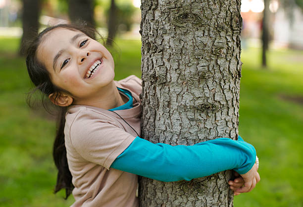 Little Girl in Nature Little happy girl hugs  the tree in National Park. hugging tree stock pictures, royalty-free photos & images