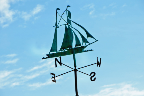 Antique weathervane in the shape of a sailing ship under full sail on an old dockside building in Newport, Rhode Island