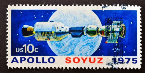 In July 1975, the United States launched the manned Apollo Command, destined to rendezvous with Russia's manned Soyuz module. A special docking station facilitated interaction among the astronauts. This stamp shows the space craft after  hookup. This is the first time two nations colaborated in space,