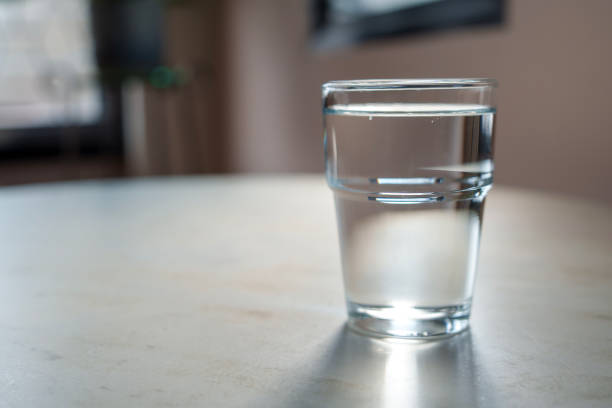 istock A glass of water on a table with sunlight shining on it, copy space. 1736580764