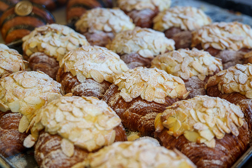 Almond croissants on a display cooling tray in a bakery store