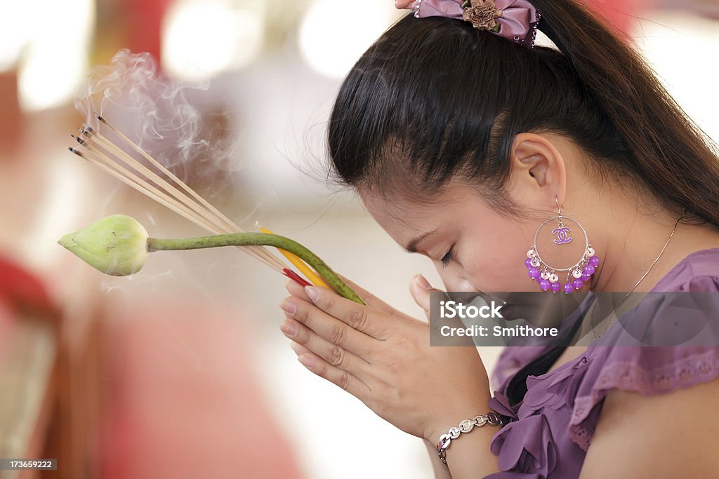 asian woman praying young asian woman praying buddha holding lotus flower and incense stick, thailand Buddha Stock Photo